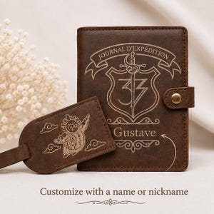 Peut inclure: Une couverture de journal en cuir marron foncé avec une fermeture à pression et une étiquette de bagage assortie. Le journal présente un bouclier gravé, une épée, le texte "JOURNAL D'EXPÉDITION" et le nom "Gustave". L'étiquette montre un personnage.