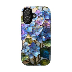 May include: A phone case featuring a stained-glass design of blue and purple hydrangea flowers with green leaves. The case has a black border and a dual-lens camera cutout.