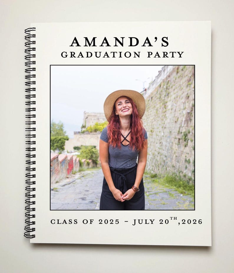 May include: A white graduation party announcement with black text. The text reads "Amanda's Graduation Party" and "Class of 2025 - July 20th, 2026". A photo of a woman wearing a straw hat and a striped shirt is in the center of the announcement.