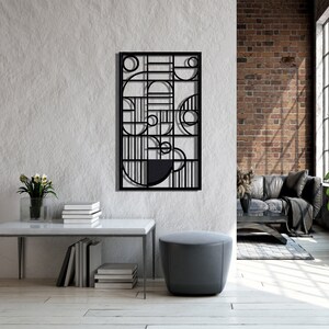 May include: Black metal wall art featuring geometric shapes and circles. The art is displayed on a white wall in a contemporary living room.