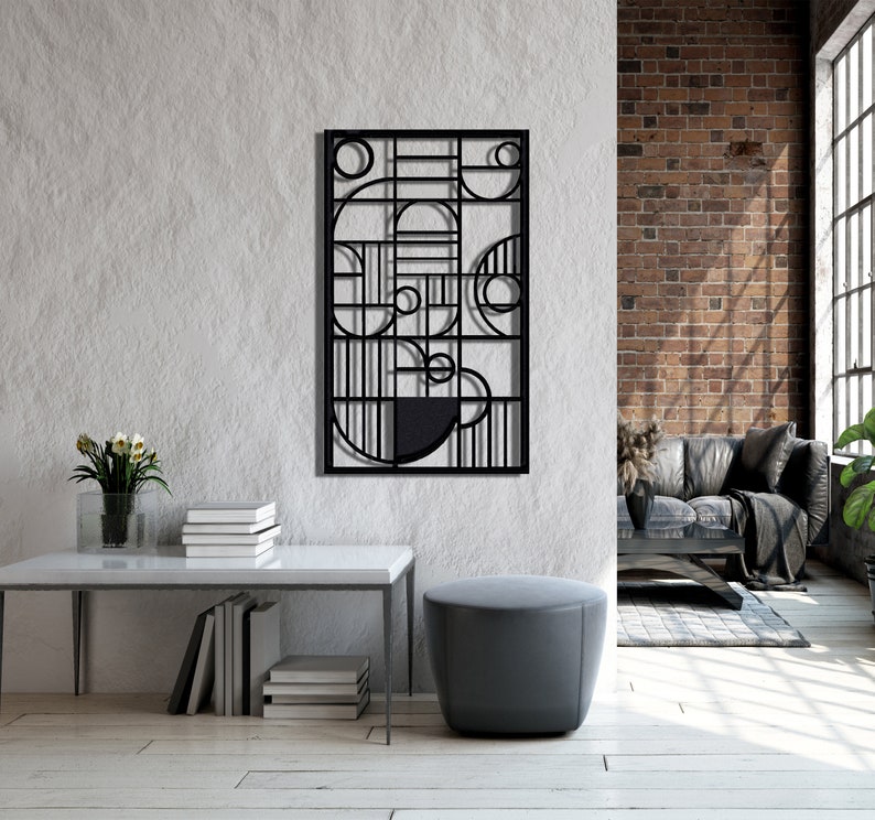 May include: Black metal wall art featuring geometric shapes and circles. The art is displayed on a white wall in a contemporary living room.