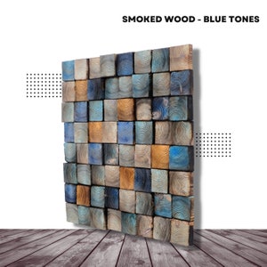 Może przedstawiać: Dekoracja ścienna wykonana z drewnianych kwadratów w odcieniach niebieskiego, brązowego i pomarańczowego. Kwadraty są ułożone w siatkę, tworząc fakturowany i wizualnie interesujący wzór. Tytuł "SMOKED WOOD - BLUE TONES" jest wyświetlany u góry obrazu.