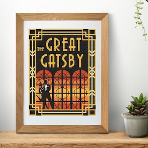 Può includere: Uno schema di ricamo a punto croce incorniciato con il titolo "The Great Gatsby" in lettere dorate con una silhouette di un uomo in smoking in piedi davanti a una finestra con uno sfondo di tramonto.