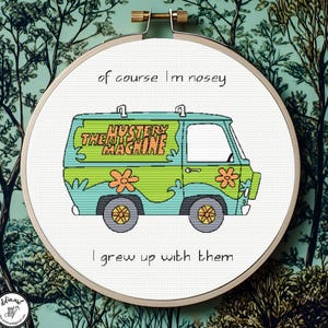 May include: A circular wooden embroidery hoop containing a cross-stitch design of a light blue and green van with orange flowers. The text "of course I'm nosey" is stitched above the van, and "I grew up with them" is stitched below the van.