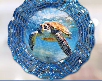 Puede incluir: Un molinillo de viento azul y blanco con purpurina que representa una tortuga marina nadando en el océano. La tortuga es marrón y amarilla con la cabeza verde. El molinillo de viento es perfecto para añadir un toque de fantasía a la decoración de tu hogar.