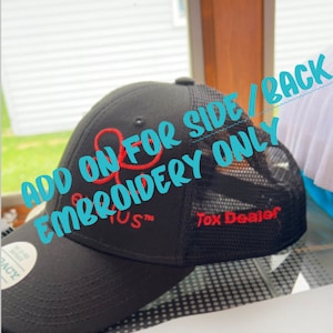 May include: Black and red embroidered trucker hat with a mesh back. The hat has the text "Add on for side/back embroidery only" and "Tox Dealer" on it.