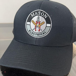 May include: Black trucker hat with a black and white embroidered logo that says "MASON ELECTRICAL" with a pair of crossed screwdrivers in the center.