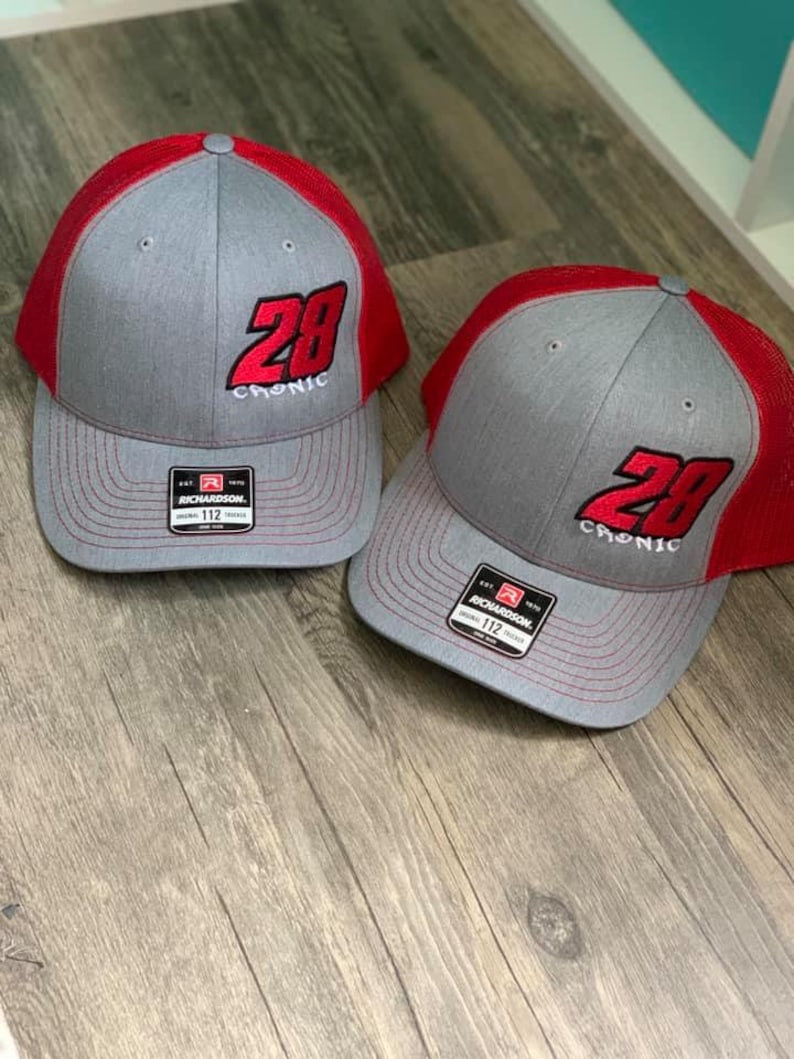 May include: Two gray and red trucker hats with a black embroidered number 28 and the word "Chronic" on the front.