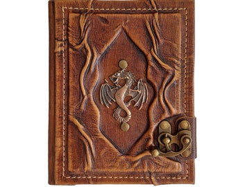 May include: A brown leather journal with a dragon emblem. The cover features embossed designs and a metal clasp. The journal is rectangular and has a stitched border. The dragon is in the center of the cover.