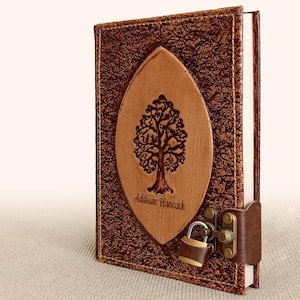 May include: Brown leather journal with a tree design and a lock. The journal is personalized with the name "Addison Hancock".