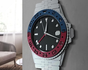 May include: A wall clock shaped like a wristwatch with a silver-toned link bracelet design. The clock face is black with white hour markers and hands, featuring a red second hand. The bezel is split into blue and red sections with black numerals.