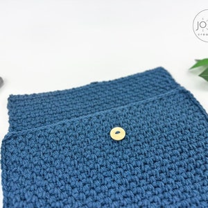 May include: A blue crocheted laptop sleeve with a wooden button closure.