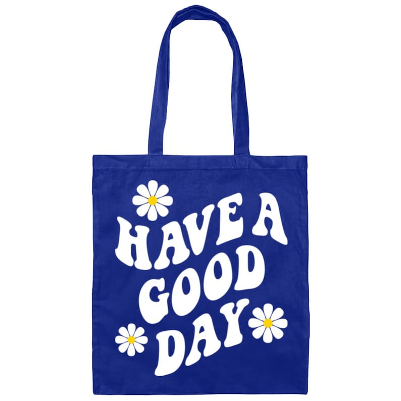 May include: A royal blue tote bag with white daisies and the text "HAVE A GOOD DAY" in a retro font.