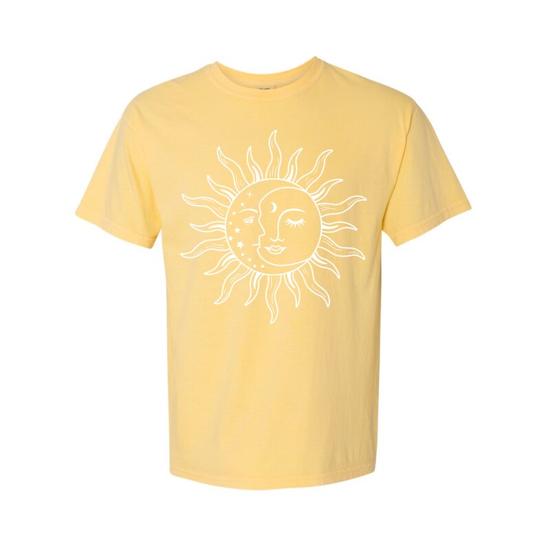 K&ouml;nnte beinhalten: Ein gelbes T-Shirt mit kurzen &Auml;rmeln und einem wei&szlig;en Sonnen- und Mondmotiv. Sonne und Mond k&uuml;ssen sich und haben ein Gesicht.
