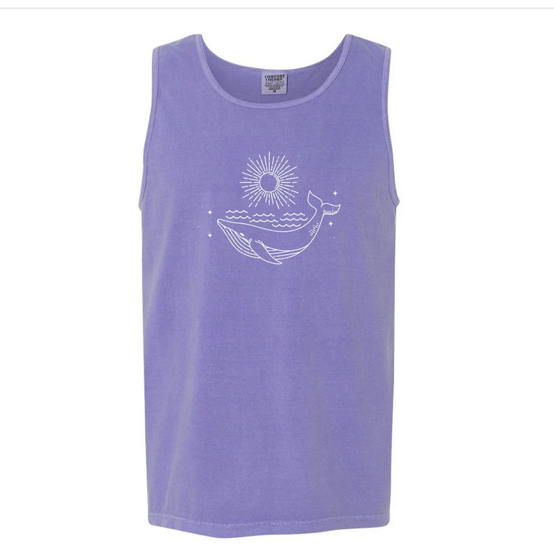 K&ouml;nnte beinhalten: Ein lilafarbenes Tanktop mit einer wei&szlig;en Umrandung eines Wals, der aus dem Wasser springt, mit einer Sonne und Sternen im Hintergrund.
