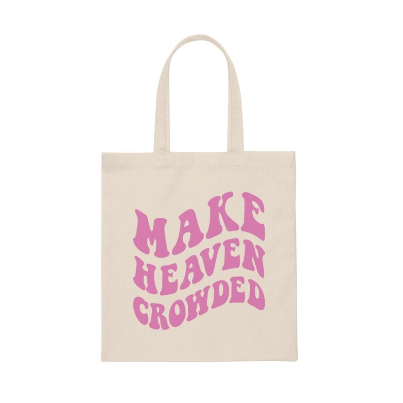 May include: A beige tote bag with pink text that reads "MAKE HEAVEN CROWDED".