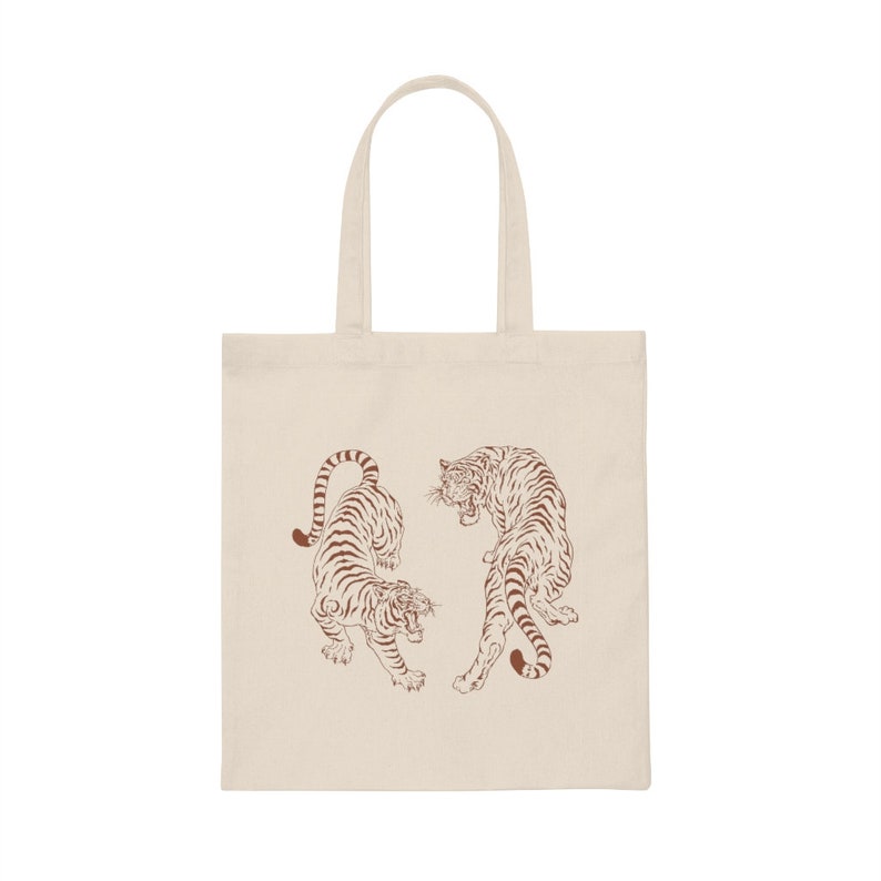 May include: A beige tote bag with two brown line drawings of tigers facing each other.