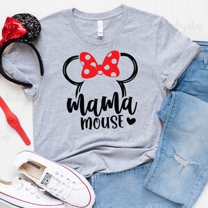 K&ouml;nnte beinhalten: Ein graues T-Shirt mit einer schwarzen Grafik von Minnie Mouse Ohren und einer roten Schleife mit wei&szlig;en Punkten. Der Text "mama mouse" ist in Schwarz unter den Ohren mit einem kleinen roten Herzen gedruckt.