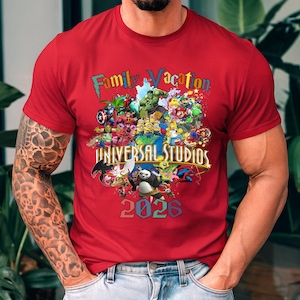 Op de afbeelding: Rood t-shirt met een kleurrijke afbeelding met verschillende stripfiguren en de tekst "Family Vacation Universal Studios 2026". Het ontwerp bevat personages van Marvel, Nintendo en andere populaire franchises.