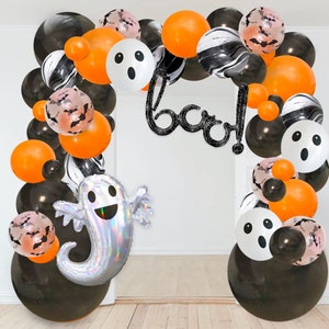 May include: Halloween balloon arch with black, orange, and white balloons. The arch is decorated with ghost balloons and a "boo!" banner.
