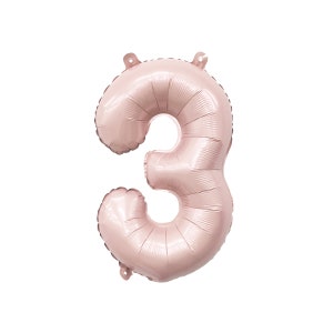 May include: A rose gold number three balloon. The balloon is inflated and ready to be used for a party or celebration.