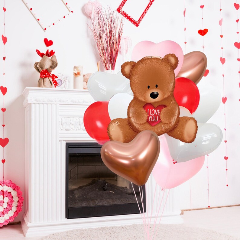 May include: A brown teddy bear holding a red heart balloon that says "I Love You". The bear is surrounded by a bouquet of heart-shaped balloons in pink, white, and gold.