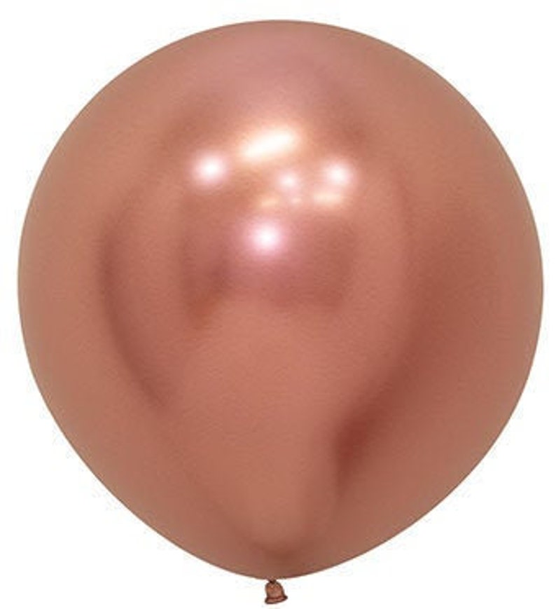 May include: A single, inflated, metallic rose gold balloon. The balloon is round and reflects light, creating highlights. The knot at the bottom is visible. The balloon is likely made of latex or a similar material.