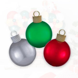 Puede incluir: Tres adornos navideños, uno verde, uno plateado y uno rojo.