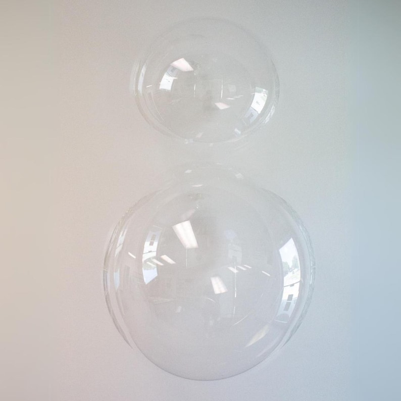 Op de afbeelding: Twee transparante plastic koepels, waarvan er &eacute;&eacute;n kleiner is dan de andere, zijn op elkaar gestapeld. De koepels zijn transparant en lijken van stevig plastic te zijn gemaakt.