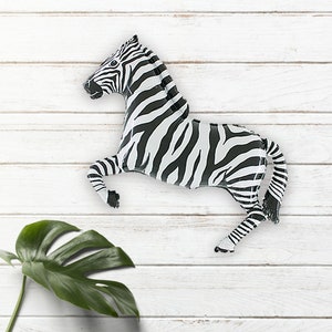 May include: Black and white zebra balloon animal. The balloon is inflated and has a 3D shape. The zebra is standing on its hind legs with its front legs raised.