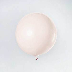 May include: A large, pale pink balloon with a white string attached to the bottom.