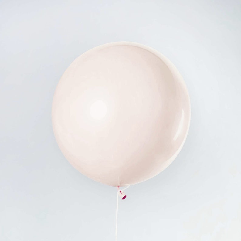 May include: A large, pale pink balloon with a white string attached to the bottom.