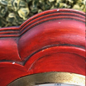 Puede incluir: Un reloj de madera rojo con un borde dorado y una esfera blanca. La esfera del reloj tiene n&uacute;meros romanos y la palabra "Caravelle" impresa en ella.