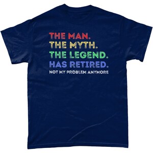 May include: Navy blue t-shirt with a rainbow gradient text design that reads "THE MAN. THE MYTH. THE LEGEND. HAS RETIRED. NOT MY PROBLEM ANYMORE."