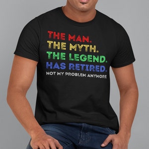 May include: A black t-shirt with a rainbow coloured graphic that reads "THE MAN. THE MYTH. THE LEGEND. HAS RETIRED. NOT MY PROBLEM ANYMORE."