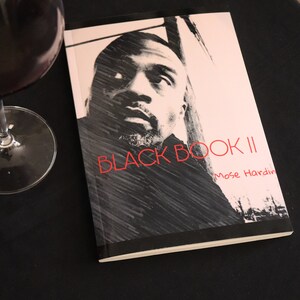 K&ouml;nnte beinhalten: Ein Schwarzwei&szlig;foto eines Mannes auf dem Cover eines Buches mit dem Titel "BLACK BOOK II" von Mose Hardin.