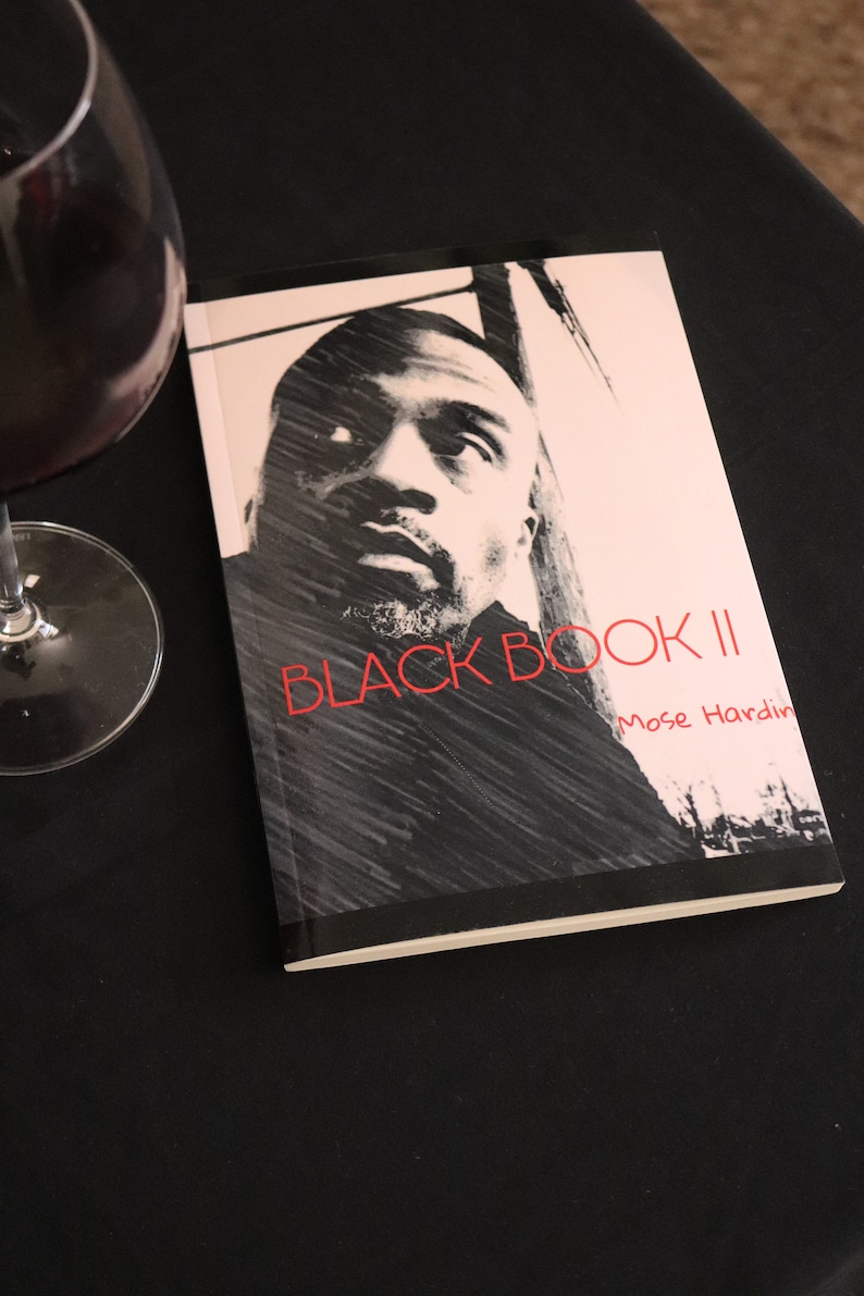 K&ouml;nnte beinhalten: Ein Schwarzwei&szlig;foto eines Mannes auf dem Cover eines Buches mit dem Titel "BLACK BOOK II" von Mose Hardin.