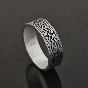 Puede incluir: Un anillo de plata con un diseño de nudo celta. El anillo está marcado con "925" en el interior.