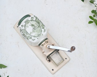 Antique coffee grinder PeDe, ceramic, wall mounted, with metal handle, with white and green.