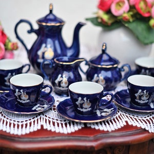 May include: A blue and white porcelain tea set with a floral design. The set includes a teapot, creamer, sugar bowl, and four teacups and saucers.