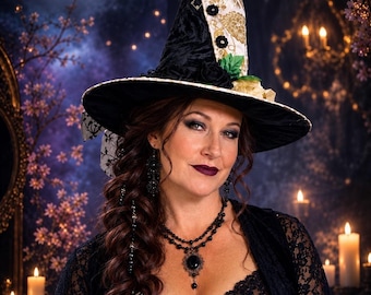 May include: A pointed hat featuring a black velvet base with a white and gold floral patterned fabric panel, accented with black fabric roses and green leaves. The hat has a wide brim and a tall, conical crown, showcasing a detailed textile design.