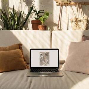 May include: A laptop computer with a white background on the screen. The screen shows a digital invitation with the text "Pearls & Magnolia" and a pearl necklace with a bow.