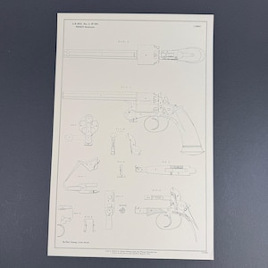 May include: A black and white technical patent drawing on paper featuring multiple views of a revolver. The print displays various components labeled with letters, including a side profile, top view, and individual mechanical parts of the firearm.