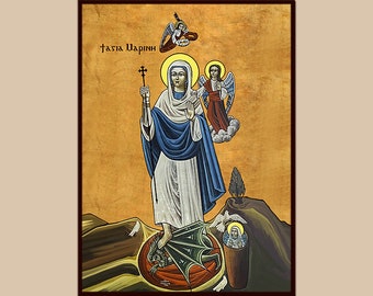 May include: A religious icon depicting a woman in a white robe and blue cloak, standing on a green dragon. She holds a cross in her right hand and is surrounded by angels. The icon is painted on a wooden panel and has a gold background. The text "Tasia Charini" is written in the top left corner.