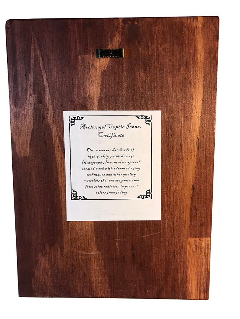 May include: A certificate for an Archangel Coptic Icon. The certificate is printed on white paper and mounted on a dark brown wooden background. The certificate states that the icons are handmade of high quality printed image (lithography) mounted on special treated wood with advanced aging techniques and other quality materials that ensure protection from solar radiation to prevent colors from fading.