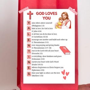 May include: A red gift bag with a white card. The card displays the text "GOD LOVES YOU" and a list of Bible verses. It includes an illustration of Jesus hugging a child, a cross, and heart shapes.