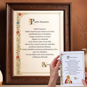 Może przedstawiać: Oprawiony wydruk Modlitwy Pańskiej w języku hiszpańskim, zatytułowany "Padre Nuestro". Tekst jest w ozdobnej czcionce, otoczony kwiatowymi obramowaniami. Mniejsza karta z tym samym tekstem jest trzymana przed ramą.