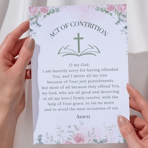 Puede incluir: Una tarjeta con el texto "ACTO DE CONTRICIÓN" y una oración. La tarjeta tiene una cruz sobre un libro abierto, con detalles florales. El texto dice "Oh Dios mío, siento de todo corazón...Amén."