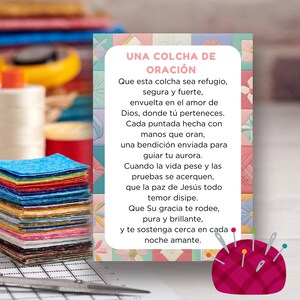 May include: A colorful stack of fabric squares next to a card with the text "UNA COLCHA DE ORACIÓN" in Spanish. The card is decorated with a patchwork design and a pin cushion with needles.