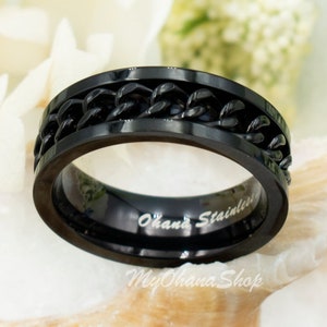 May include: Black stainless steel ring with a chain design. The ring is engraved with the words "Ohana Stainless".